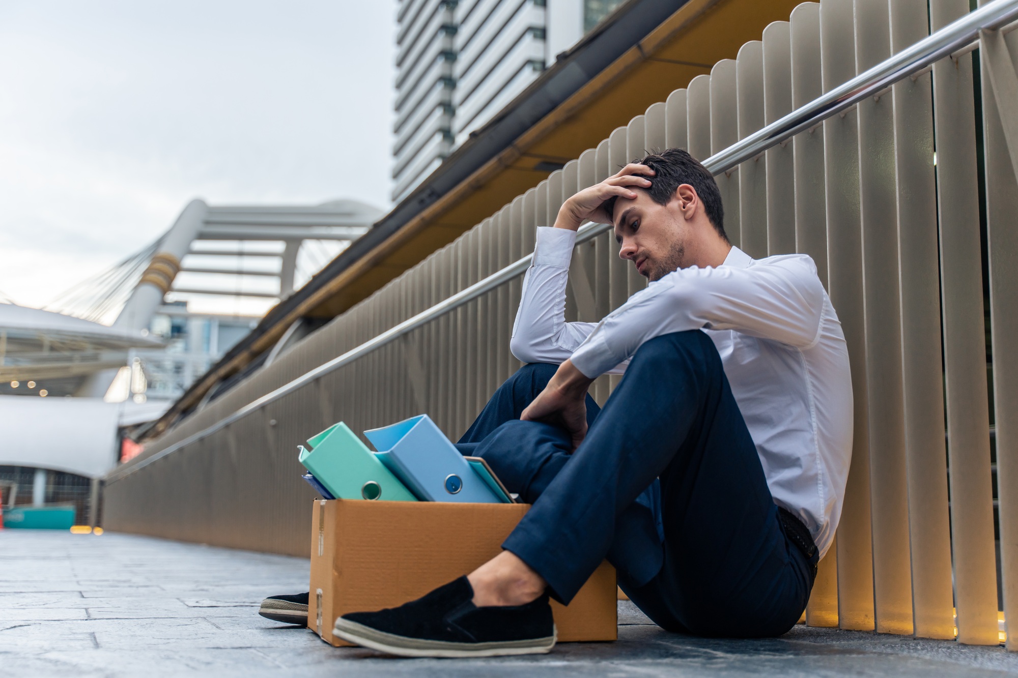 Caucasian businessman sitting outdoor after unemployment from company.